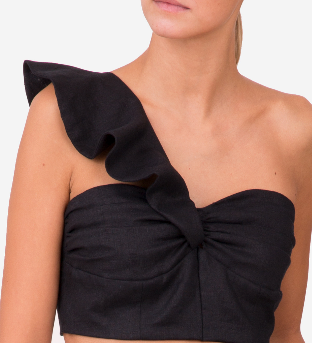 Model wearing one-shoulder linen crop top with ruffle detail and bustier front — sustainable resortwear from 6ShoreRoad